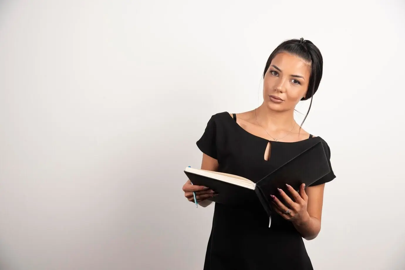 開いたノートとともにポーズをとる真面目な従業員